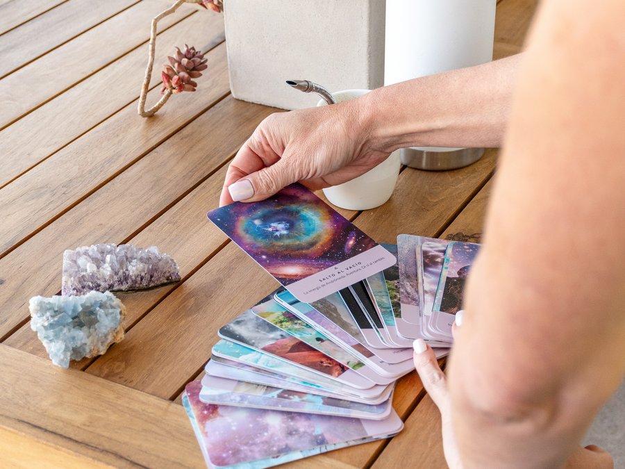 Una mano eligiendo una carta, entre cristales