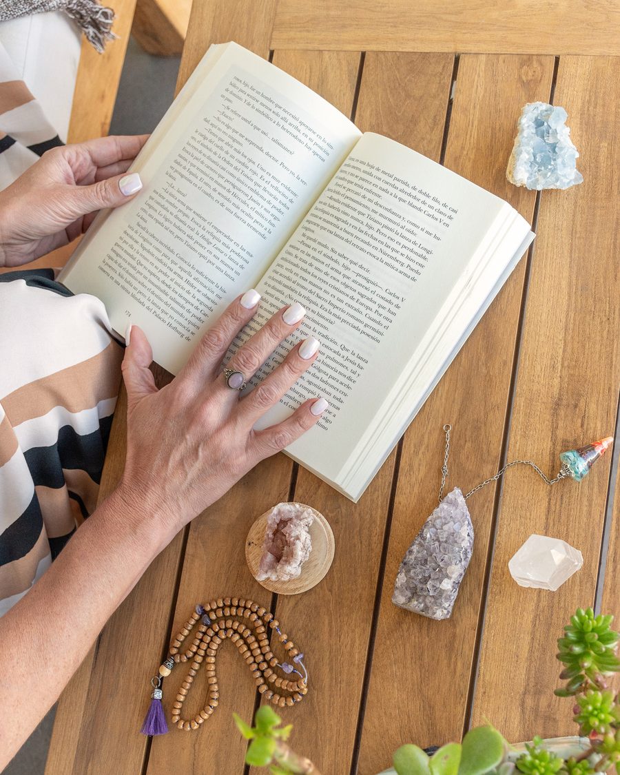 Manos sobre un libro abierto, rodeado de cristales